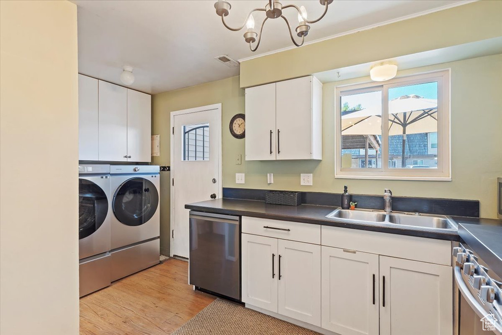 Kitchen featuring dishwasher, separate washer and dryer, a sink, white cabinets, and dark countertops
