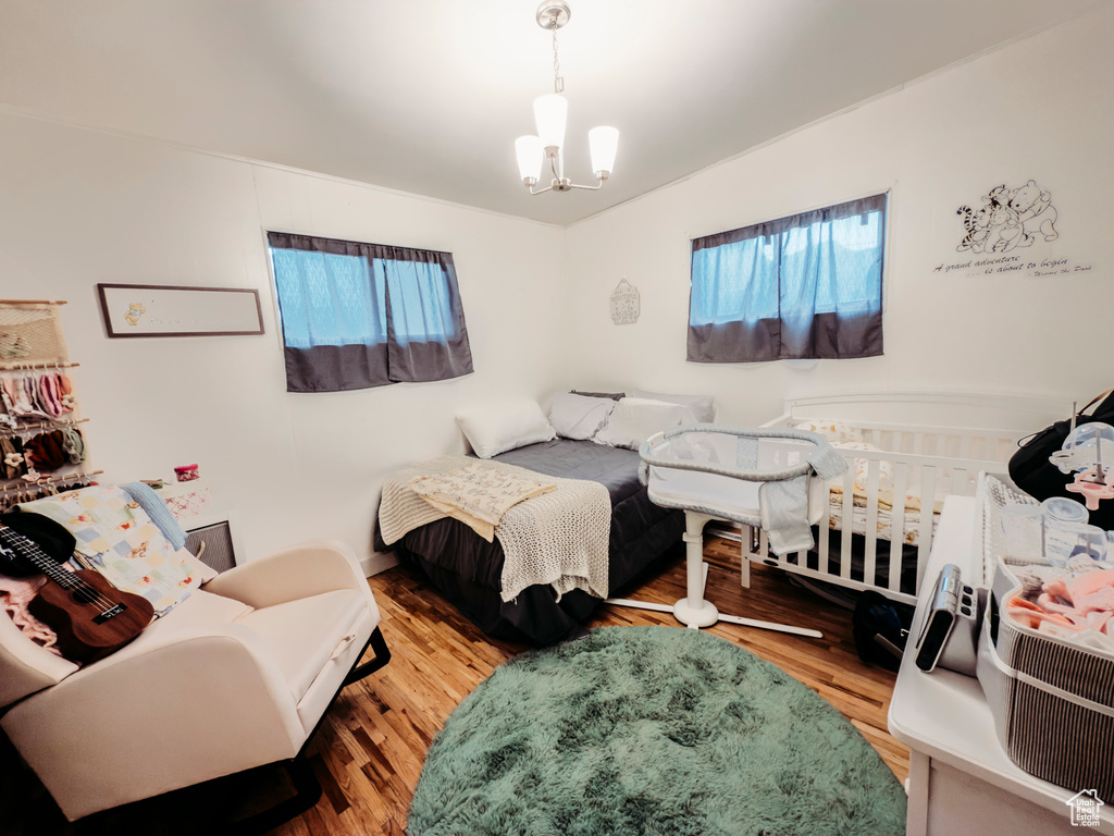 Bedroom featuring wood finished floors and a chandelier