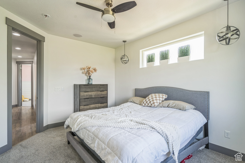 Carpeted bedroom with baseboards and a ceiling fan