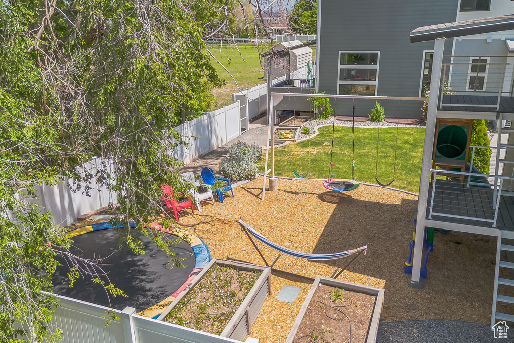 View of yard featuring a playground and a vegetable garden