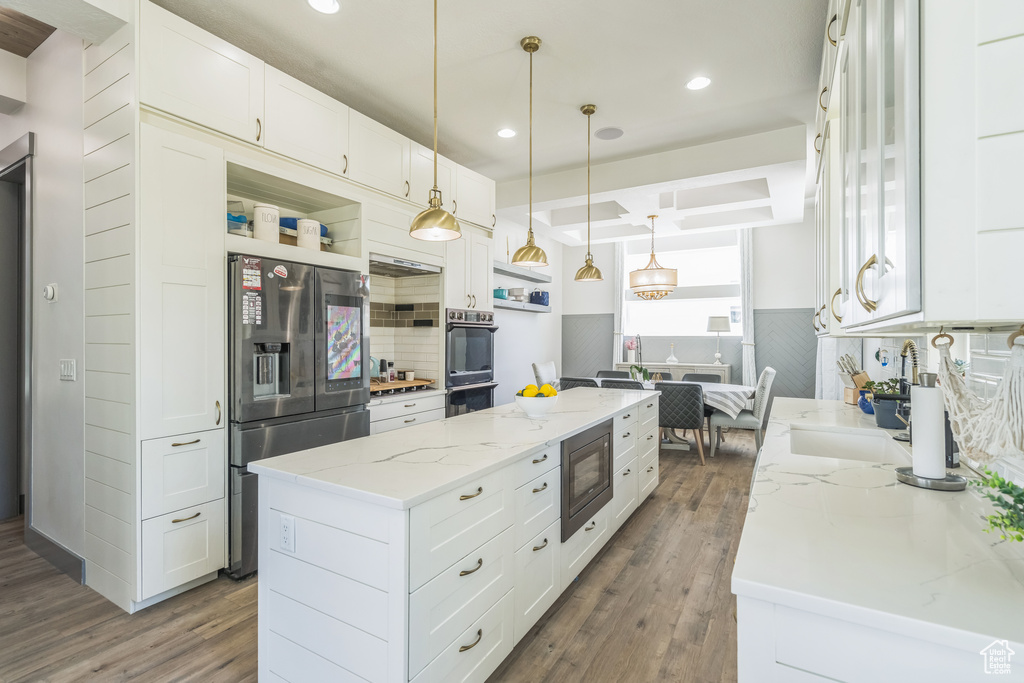 Kitchen featuring stainless steel appliances, open shelves, dark wood-style floors, a center island, and recessed lighting