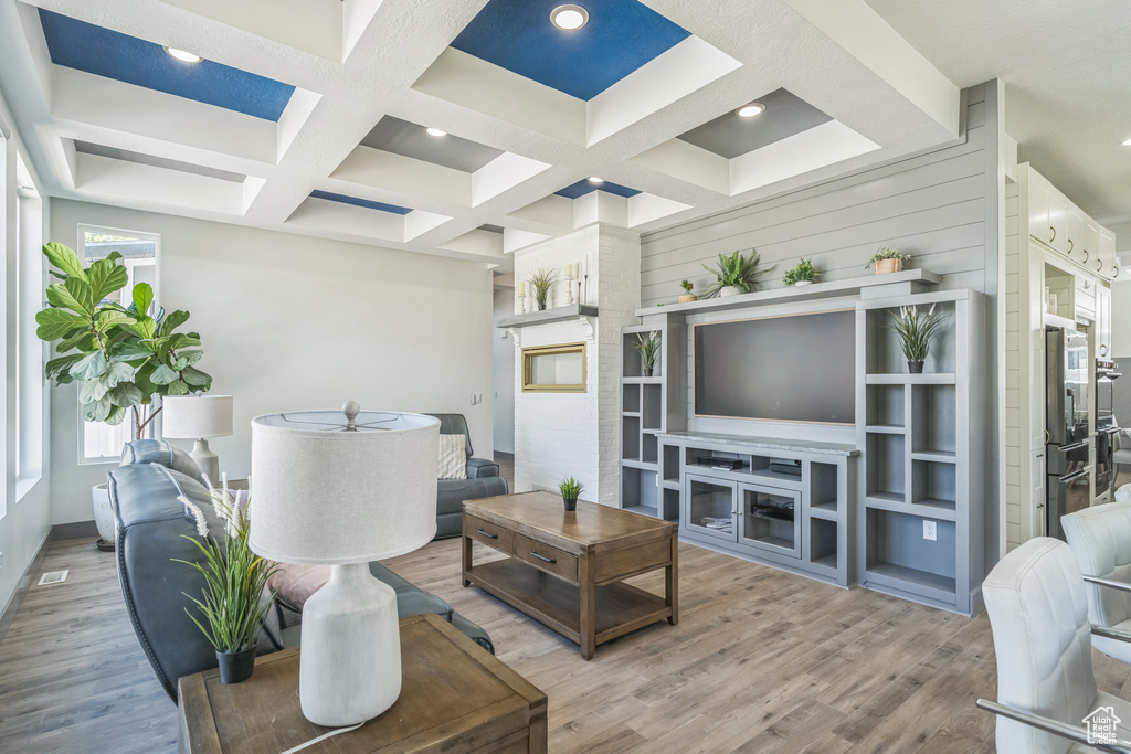 Living area with light wood finished floors, coffered ceiling, beam ceiling, recessed lighting, and baseboards