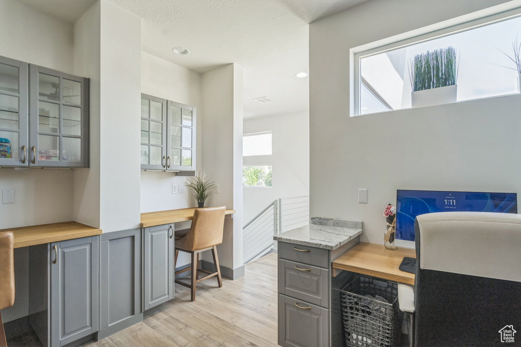 Office area with light wood-style floors and recessed lighting