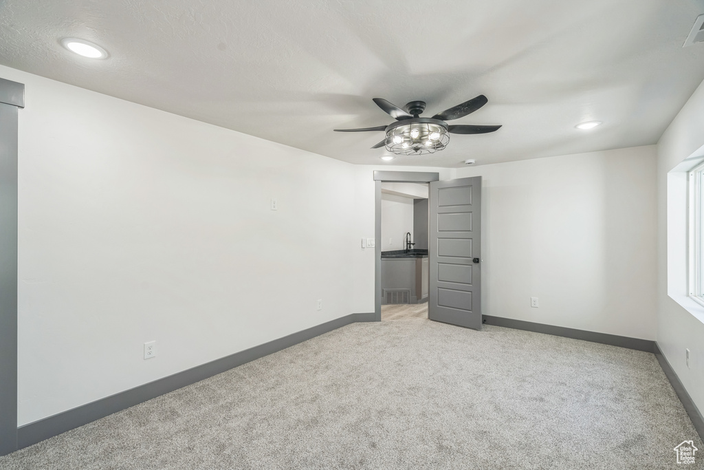 Unfurnished room with ceiling fan, light colored carpet, baseboards, and recessed lighting