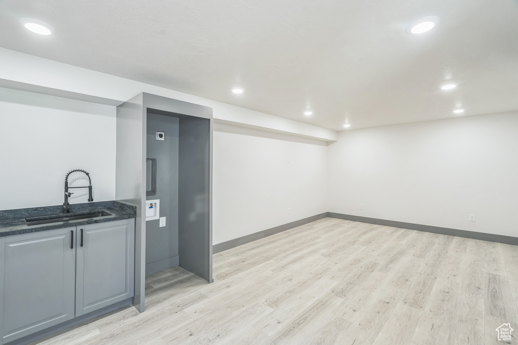Bar featuring a sink, light wood-style flooring, recessed lighting, and baseboards