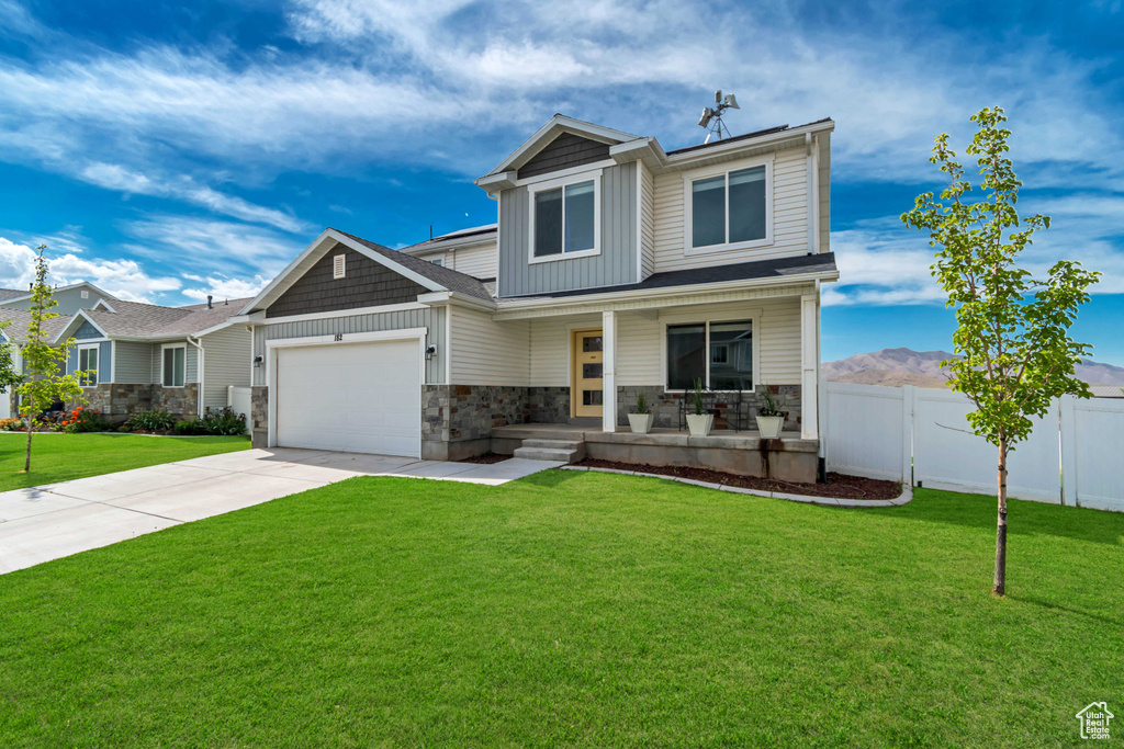 Craftsman house with covered porch, stone siding, board and batten siding, a garage, and concrete driveway