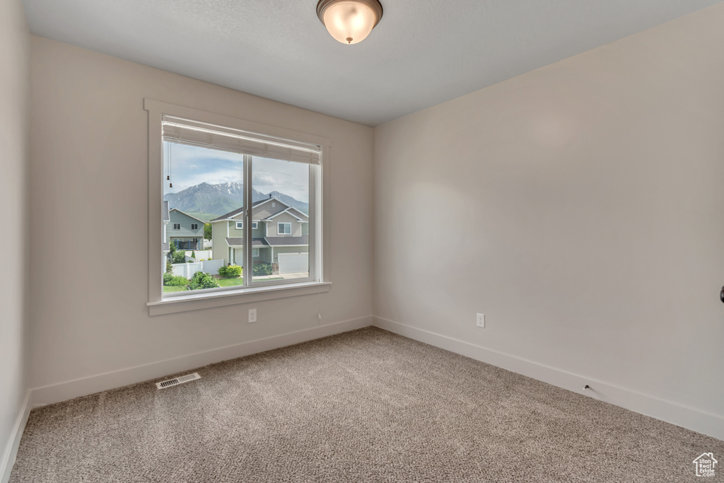 Empty room featuring carpet and baseboards
