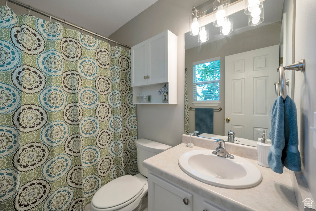 Full bath with vanity, toilet, and a shower with curtain