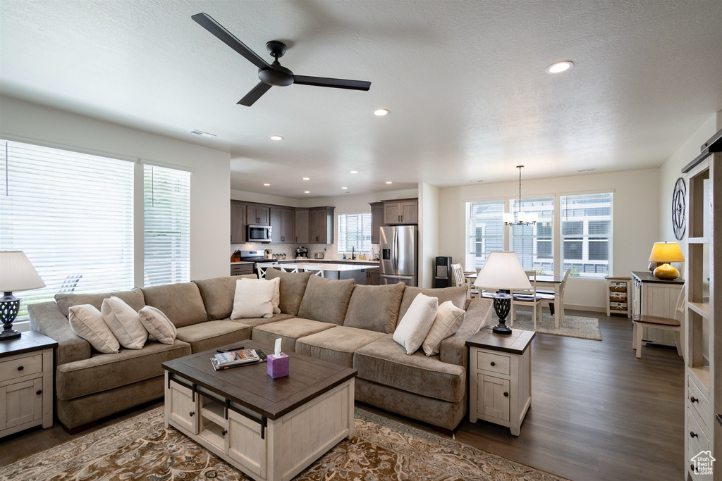 Living area with wood finished floors, plenty of natural light, ceiling fan, and recessed lighting