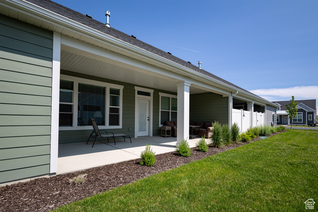 Rear view of property with a yard and a patio area