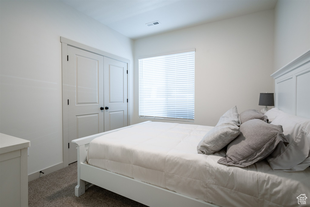 Bedroom featuring carpet and a closet