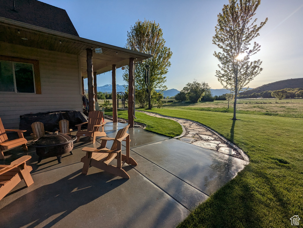 View of patio with an outdoor fire pit and a mountain view