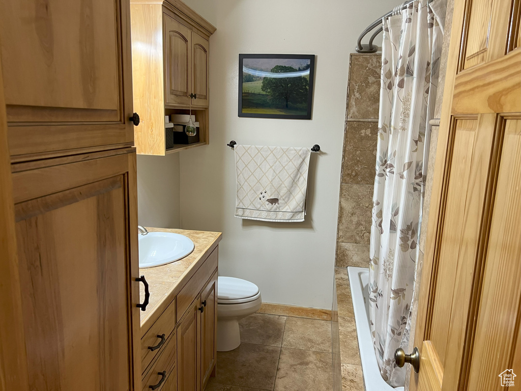 Full bath featuring toilet, vanity, and baseboards