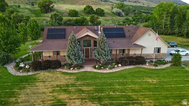 View of front of house featuring a front yard and roof mounted solar panels