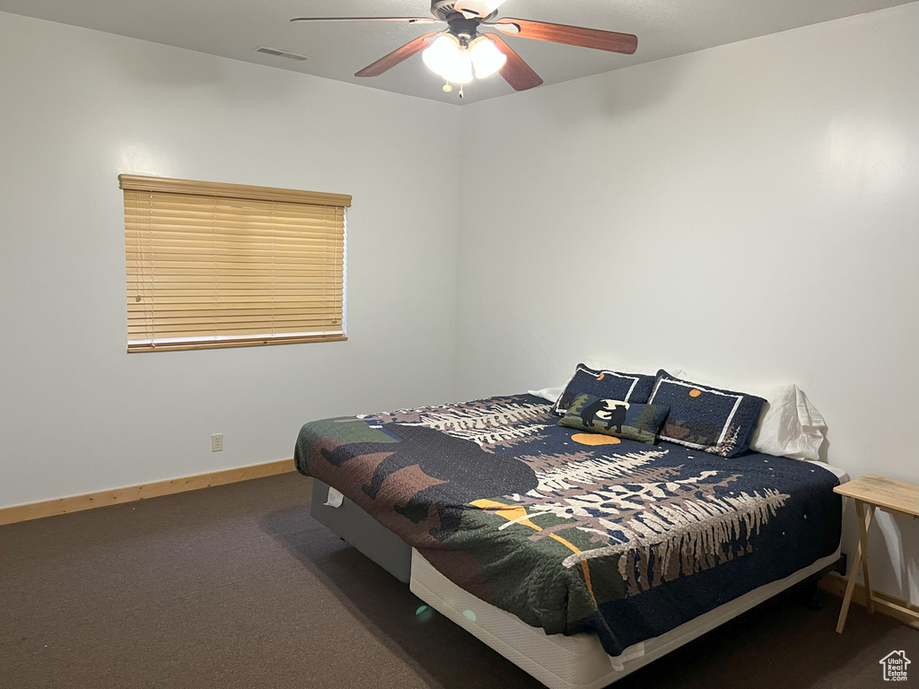 Bedroom featuring carpet floors, baseboards, and ceiling fan