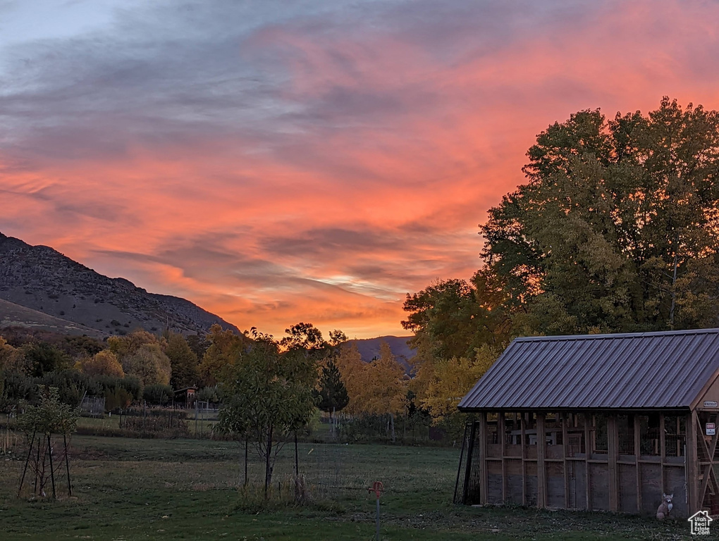 View of grassy yard with an outbuilding and a mountain view