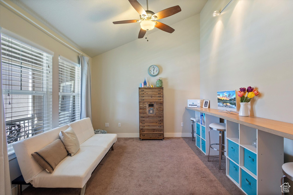 Living area featuring vaulted ceiling, ceiling fan, carpet floors, and baseboards