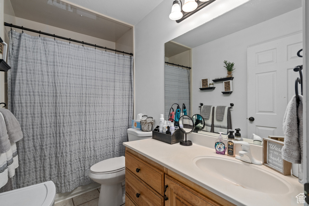 Bathroom featuring toilet, vanity, and tile patterned floors