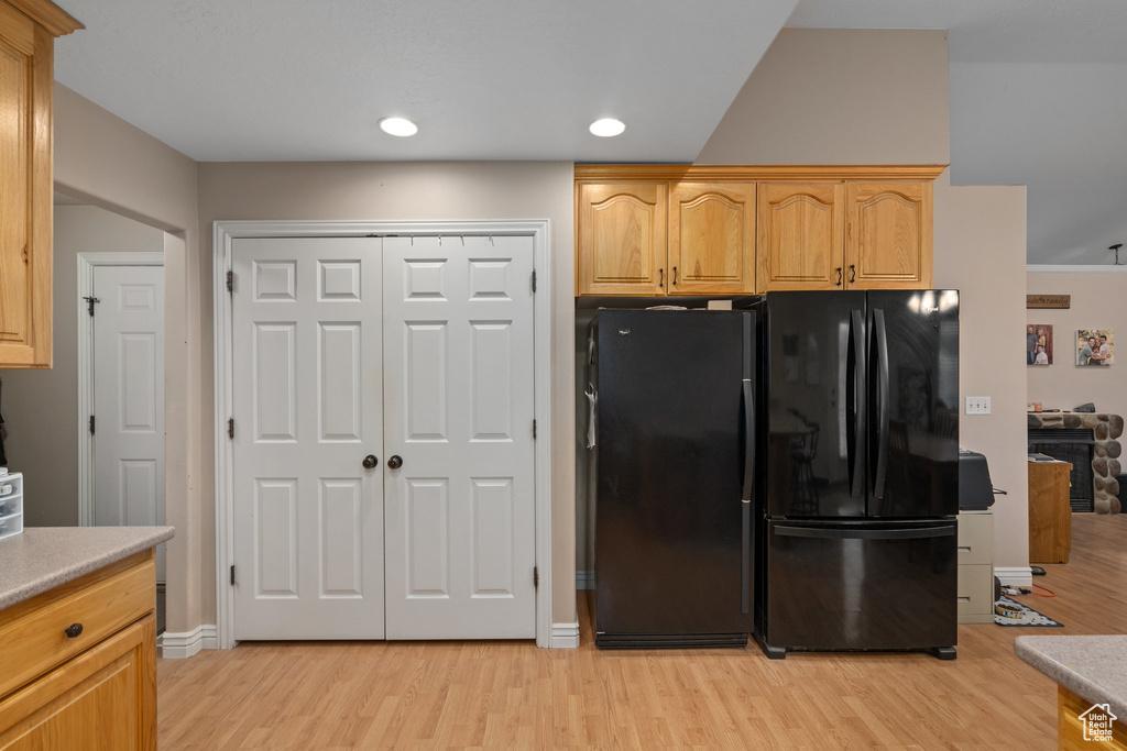 Kitchen with light wood-style flooring, freestanding refrigerator, light countertops, and recessed lighting