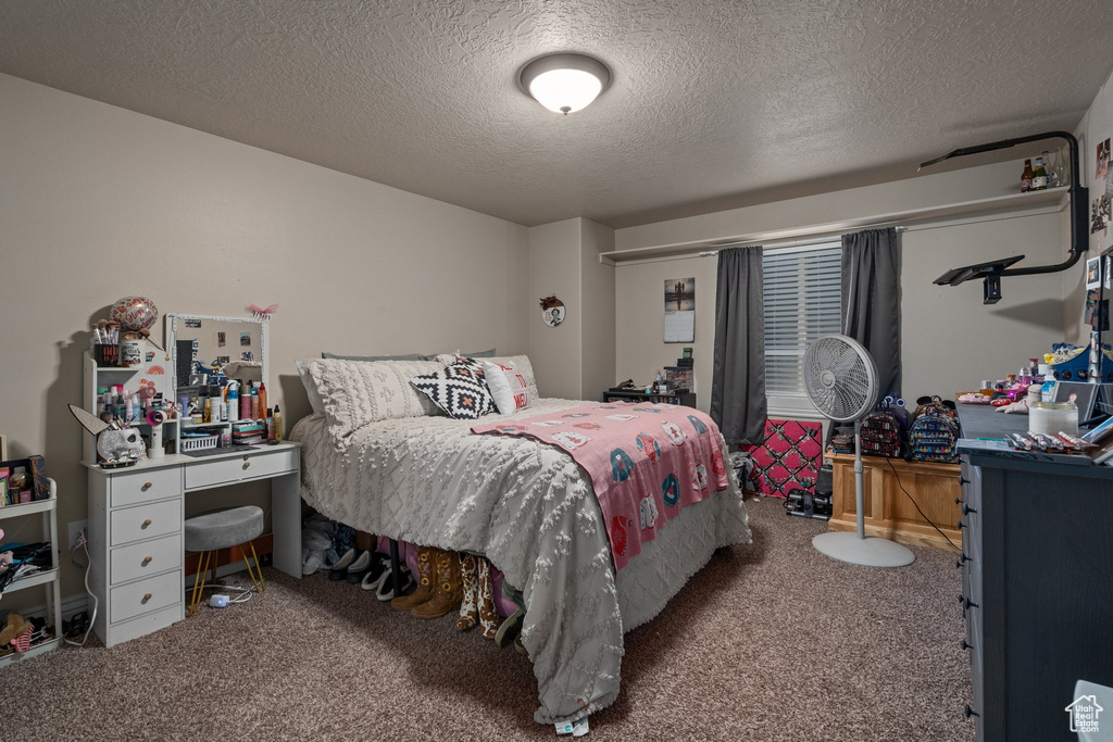 Carpeted bedroom featuring a textured ceiling