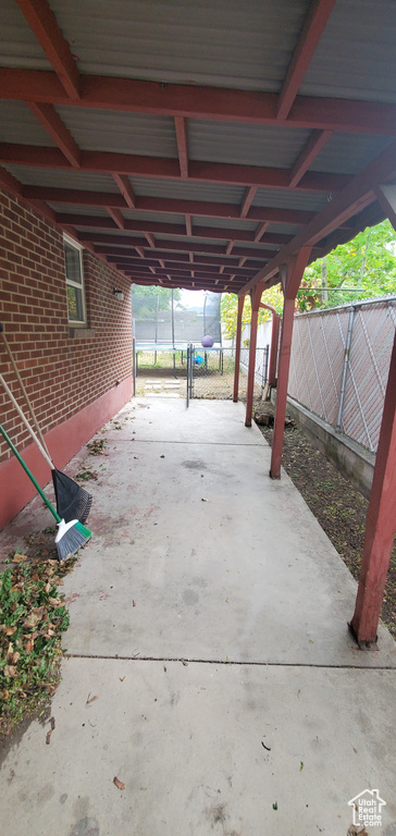 Fenced backyard featuring a carport and driveway
