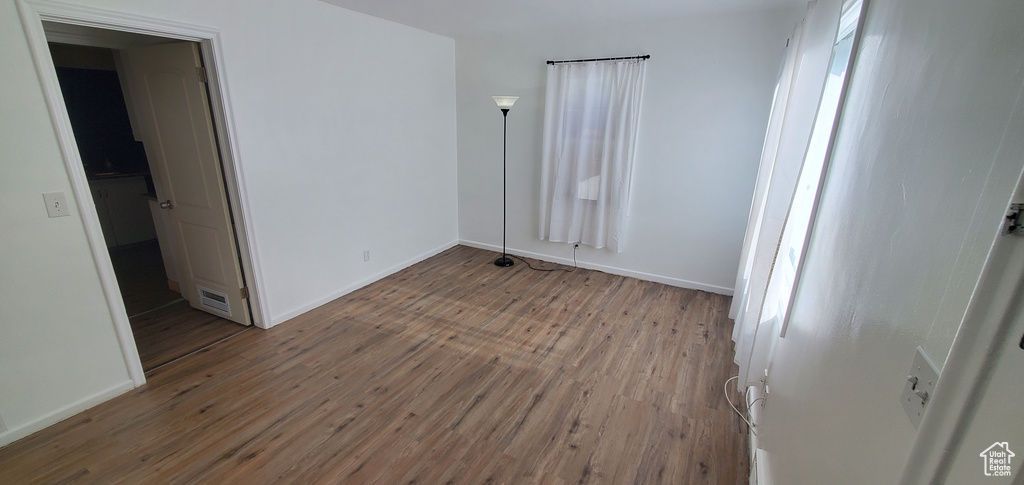 Unfurnished room with wood finished floors and baseboards