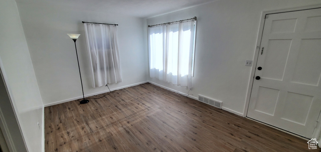 Unfurnished room with wood finished floors and baseboards