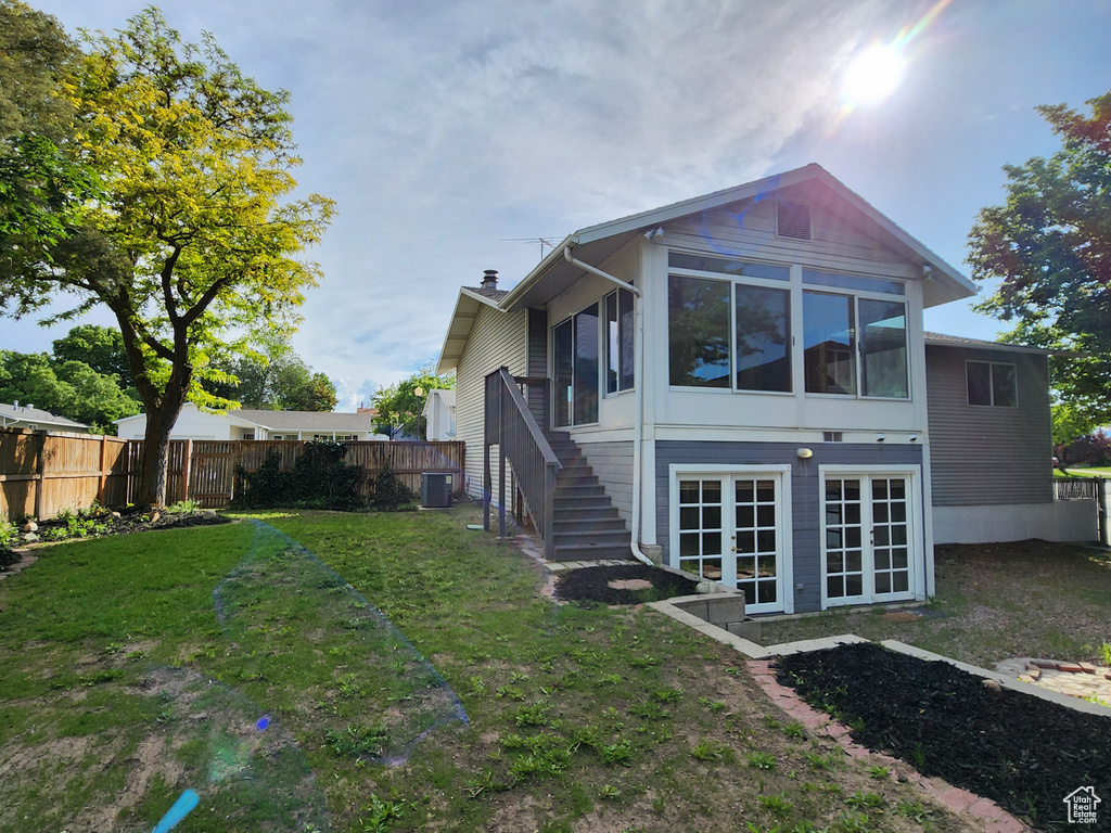 Rear view of property featuring stairs, a sunroom, and cooling unit