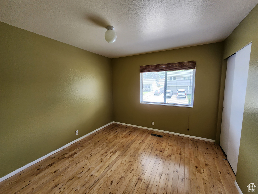 Empty room with light wood-type flooring and baseboards