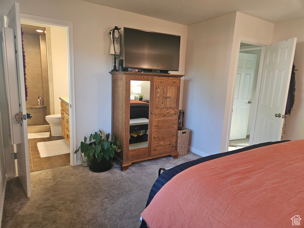 Bedroom featuring carpet floors, ensuite bathroom, and baseboards