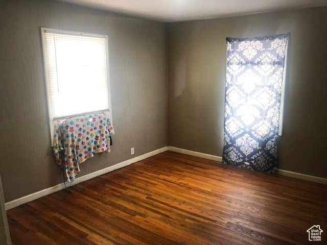 Unfurnished room featuring wood finished floors and baseboards