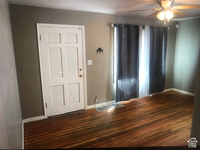 Entryway with ceiling fan, baseboards, and wood finished floors