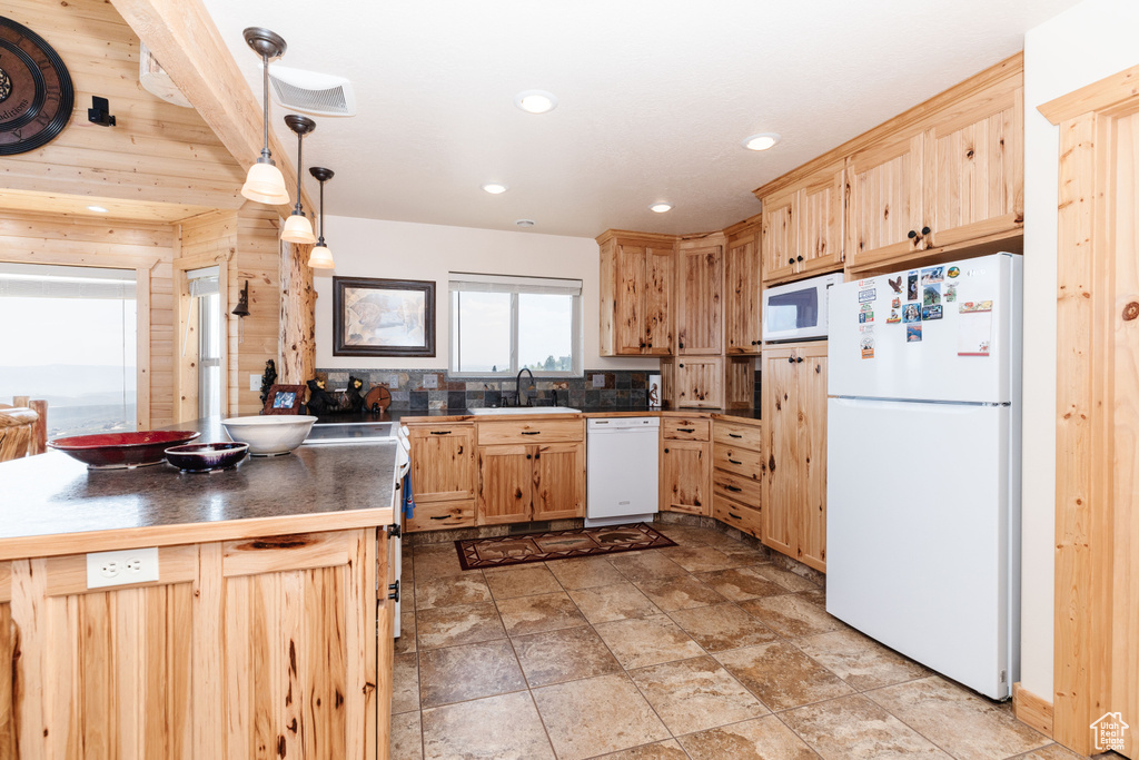 Kitchen featuring white appliances, a sink, light brown cabinets, recessed lighting, and pendant lighting