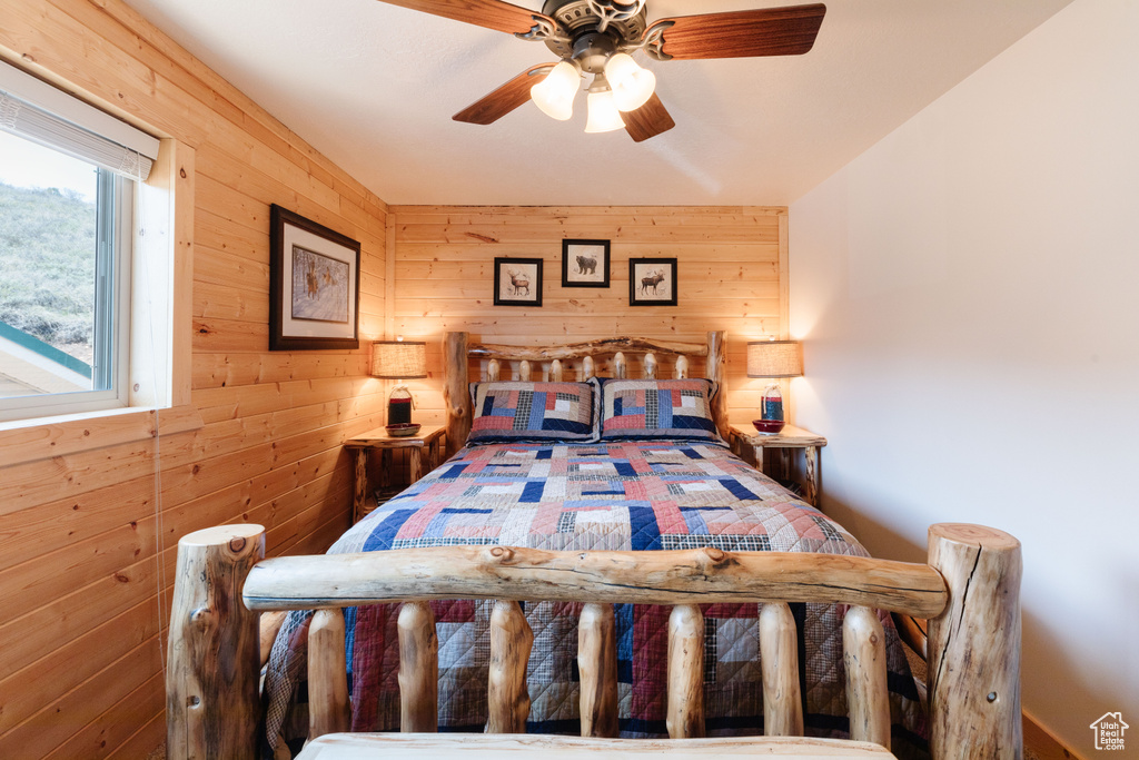 Bedroom with wood walls and ceiling fan