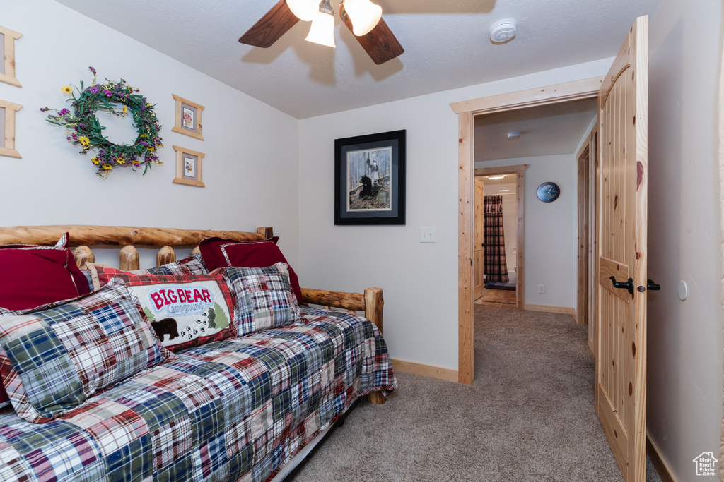 Carpeted bedroom featuring baseboards and a ceiling fan