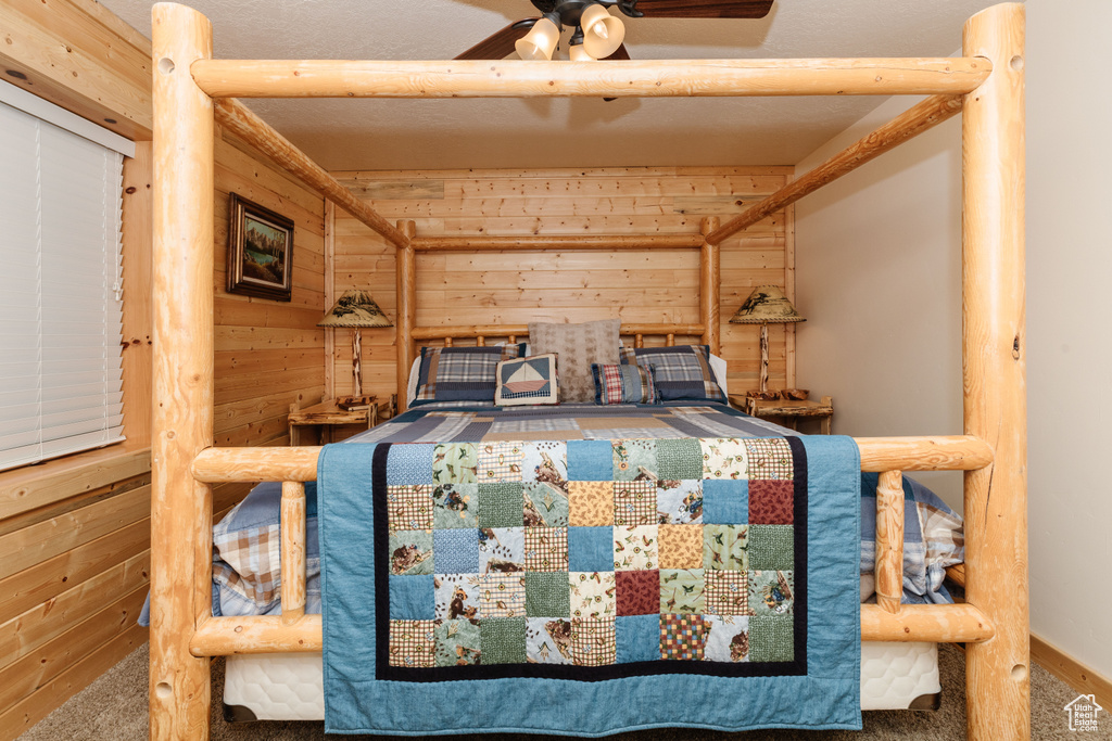 Bedroom featuring wooden walls and carpet flooring