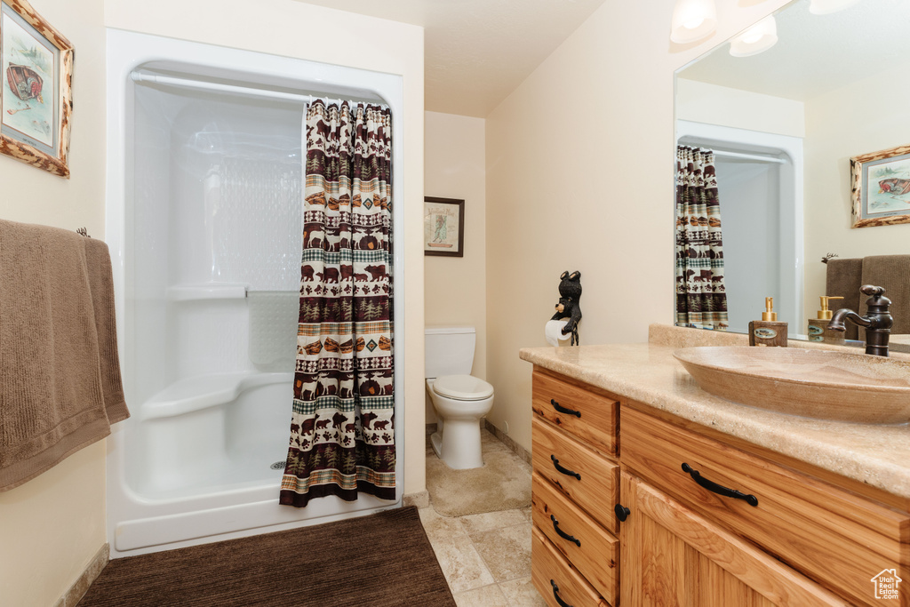 Full bathroom with vanity, toilet, a shower with curtain, and tile patterned floors