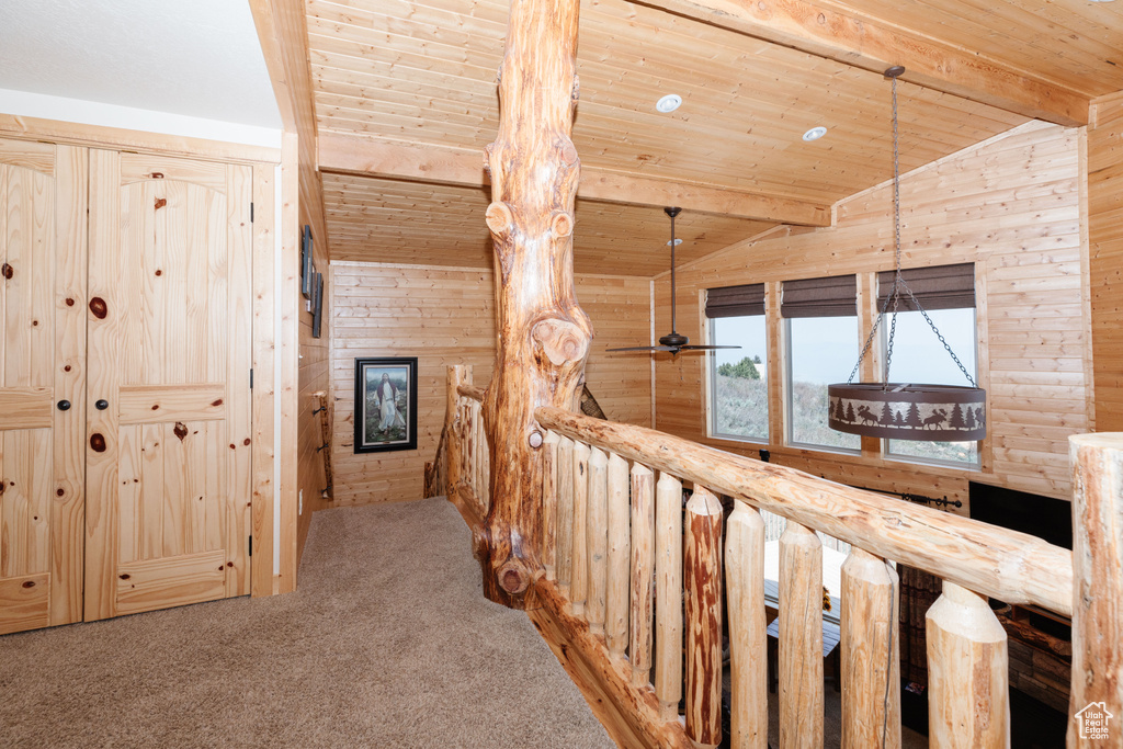 Corridor with wooden ceiling, carpet flooring, and wood walls