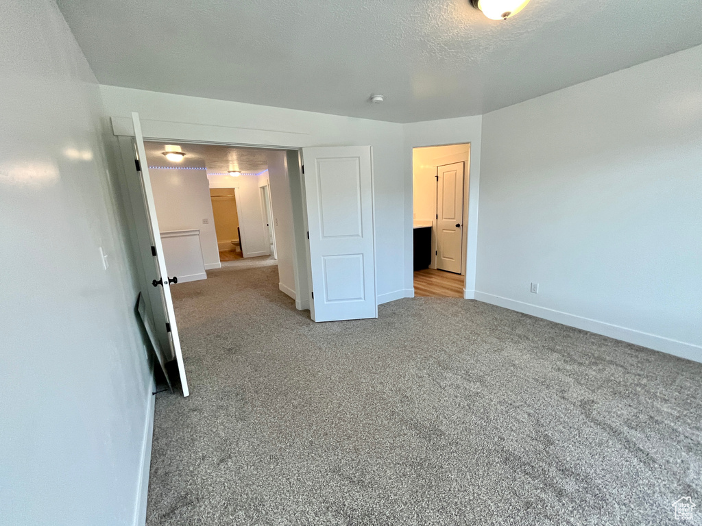 Unfurnished bedroom featuring baseboards and carpet