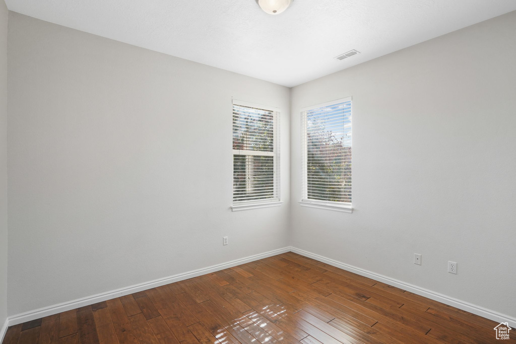 Spare room featuring baseboards and hardwood / wood-style floors