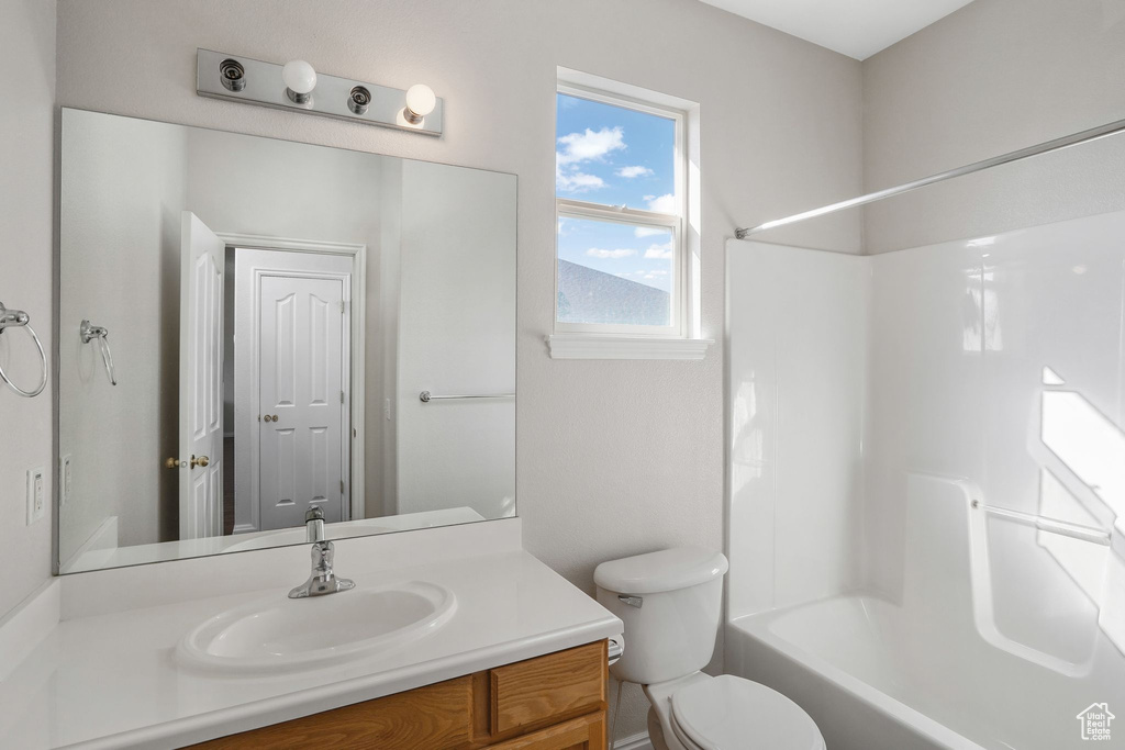 Full bathroom featuring vanity, shower / tub combination, and toilet
