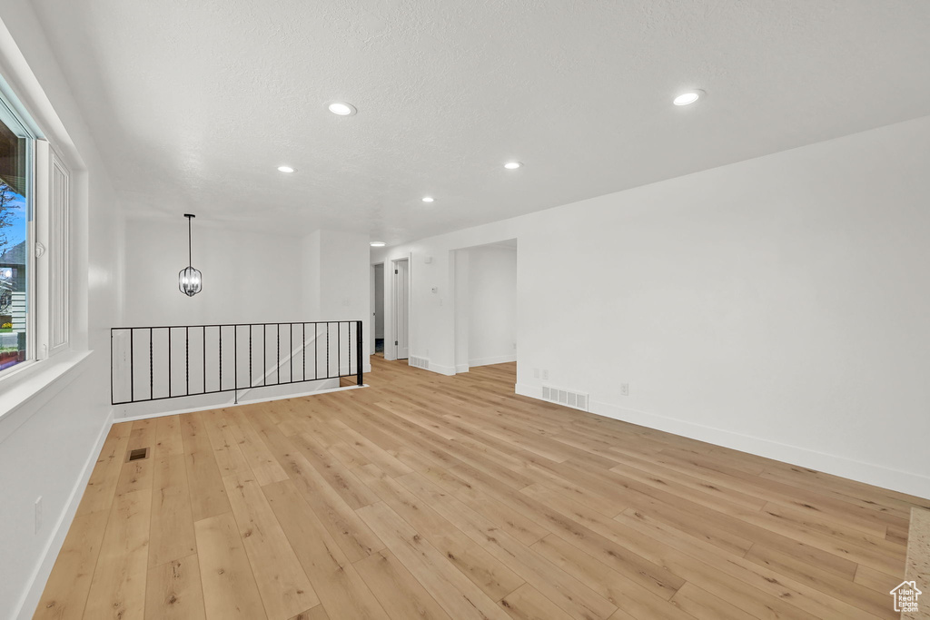 Spare room featuring light wood-type flooring, recessed lighting, and baseboards