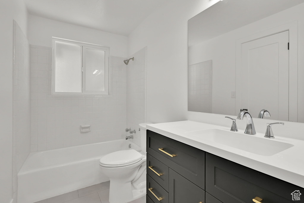 Bathroom featuring vanity, tub / shower combination, toilet, and tile patterned floors