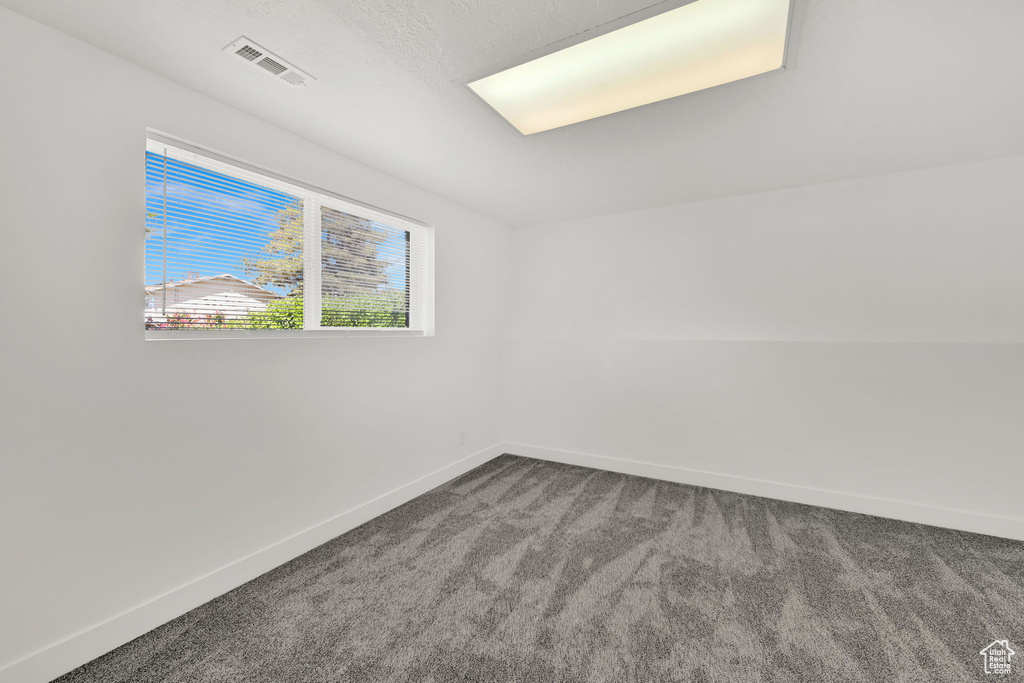 Carpeted empty room featuring baseboards