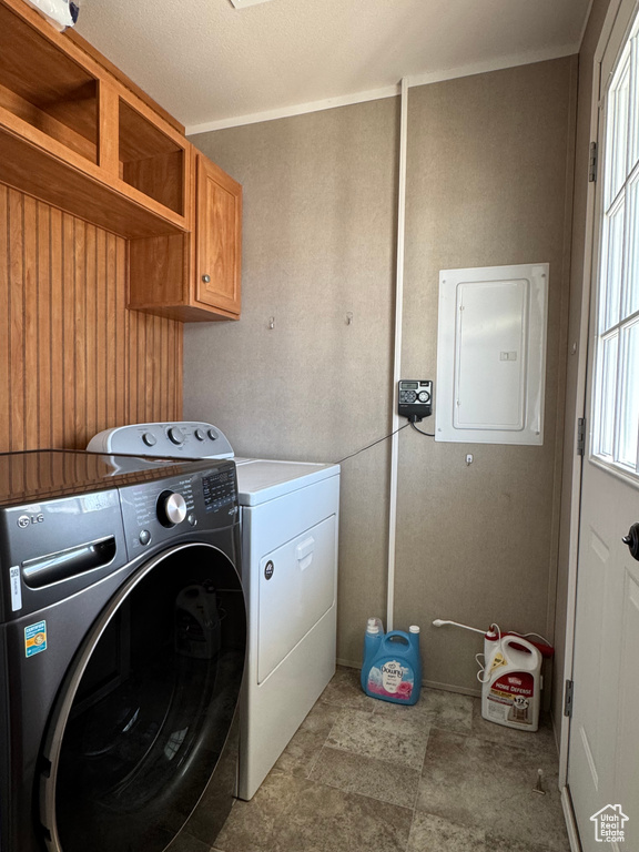 Laundry area with electric panel, washer and dryer, and cabinet space