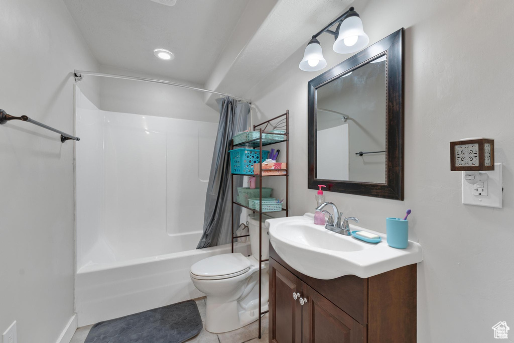 Full bath featuring shower / tub combo with curtain, vanity, and toilet