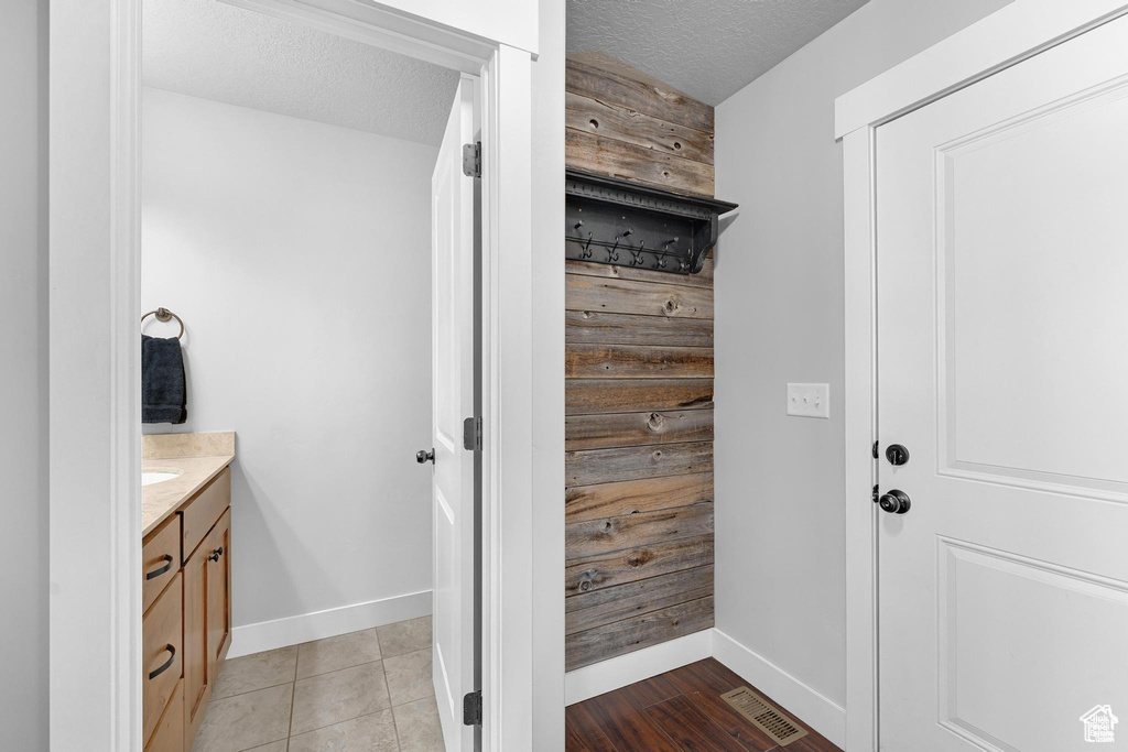 Interior space featuring baseboards, vanity, and a textured ceiling