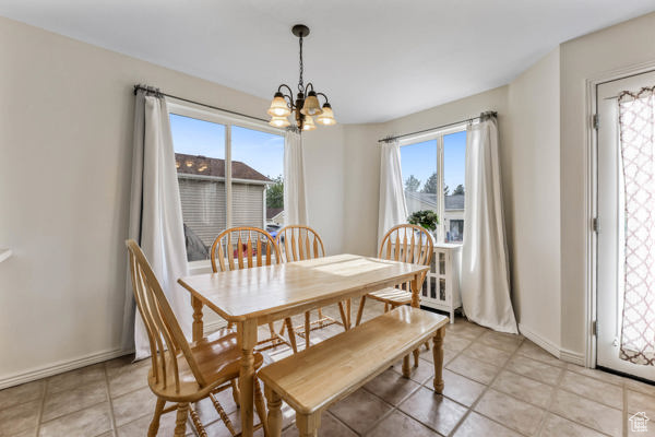 Dining room featuring a chandelier, light tile patterned floors, and baseboards