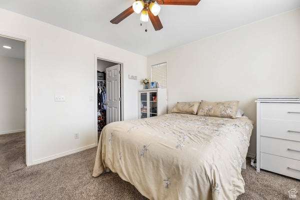 Bedroom featuring carpet flooring, a walk in closet, baseboards, and a closet
