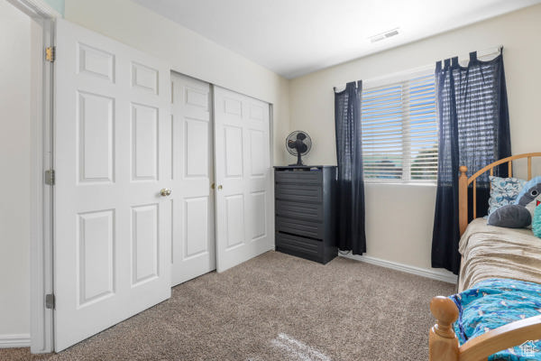 Bedroom featuring carpet, a closet, and baseboards